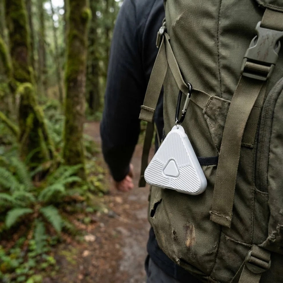 Pulse ultrasonic tick repeller clipped to a hiker's backpack on a forest trail